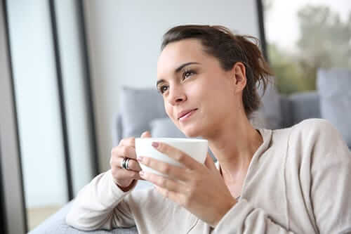Smiling woman with coffee during our 12 step recovery program