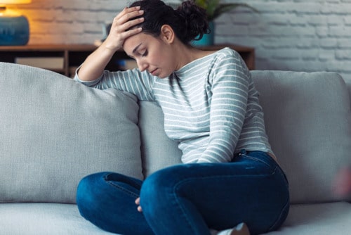 woman holding head distressed at the beginning of the benzo withdrawal timeline