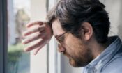 pensive man leaning head against hand against window needs anxiety treatment