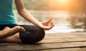 a woman finding the benefits of mediating near a lake