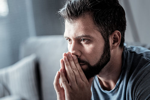 Man with hands to mouth thinking about a benzo addiction treatment program