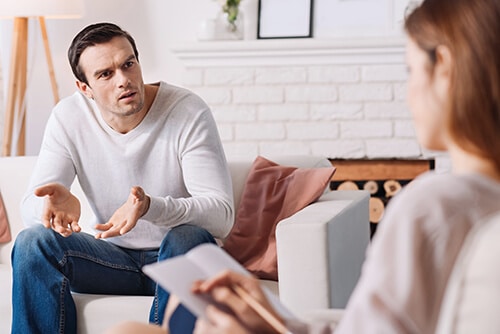 Man and counselor involved in cognitive behavioral therapy or CBT
