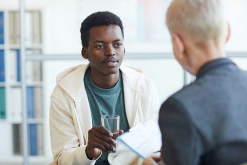 a young man talking to his doctor about coping skills