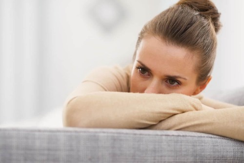 woman with thousand yard stare on couch needs depression treatment