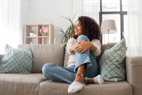 woman sitting on a couch thinking about detoxing at home