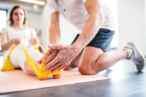 Instructor helping client stretch during exercise therapy at Kemah Palms physical fitness program