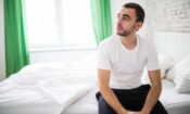 white man on bed wondering how to get off opioids