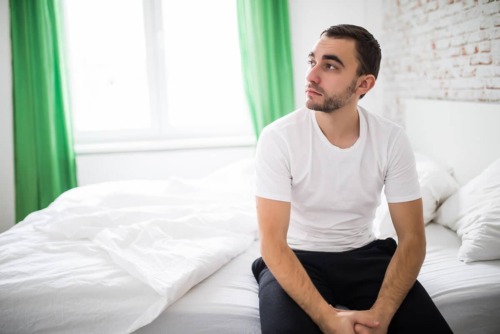 white man on bed wondering how to get off opioids