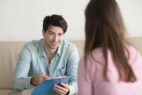 Male counselor with clipboard during individual therapy for addiction