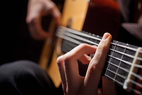 a person playing guitar as part of Music Therapy