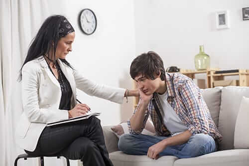 Female counselor talking to upset young man at our opiate addiction treatment center