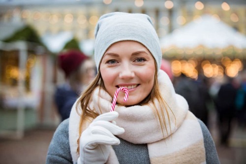 a woman eating a candy cane learning how to stay sober over the christmas holiday