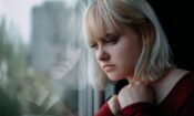 pensive young woman looking out a window thinking about how to recognize unhealthy coping skills