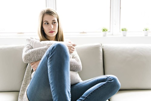 Woman sitting on the couch holding a pillow