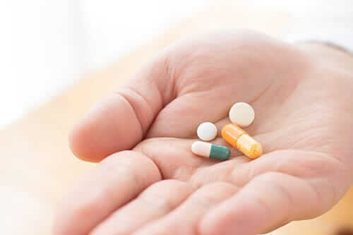 man holding a handful of pills needing opiate detox