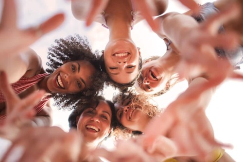 Young adults in a circle smiling