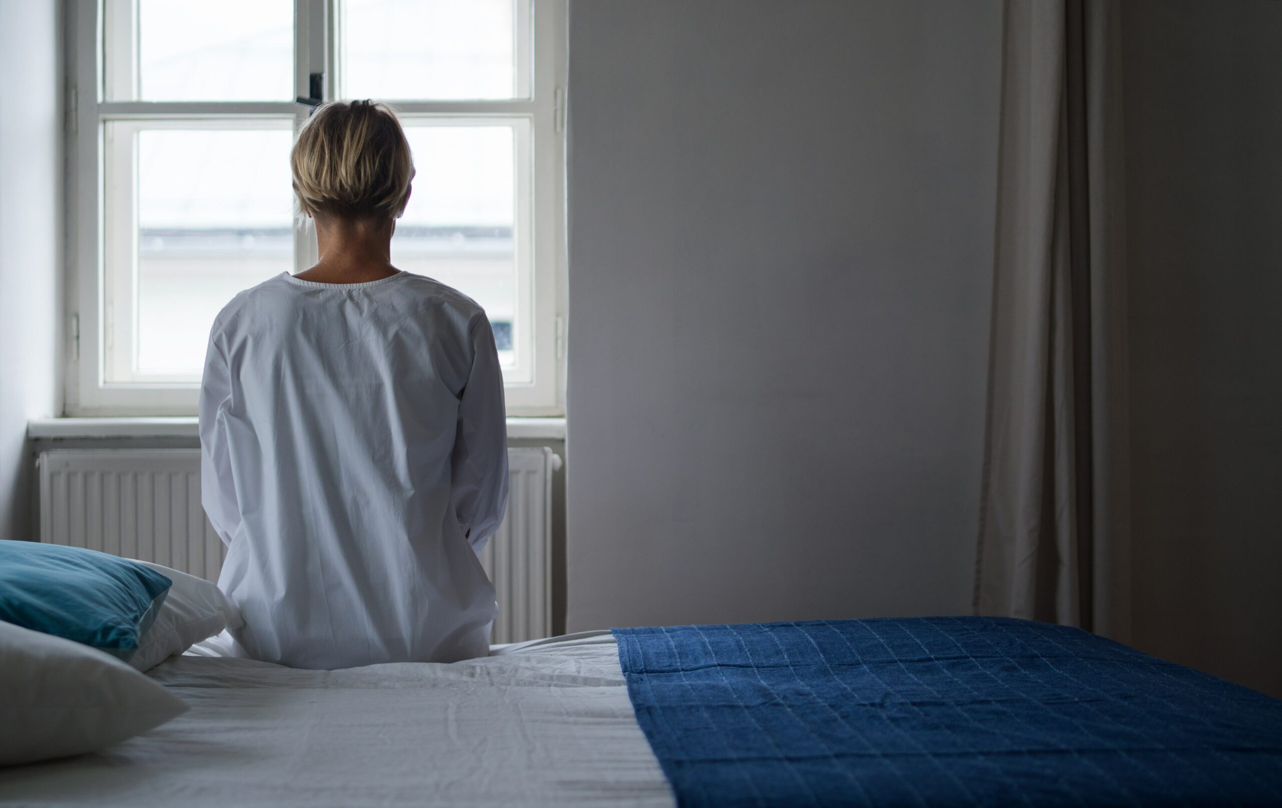 A woman on a bed in stimulant detox in Houston.