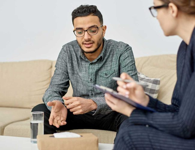 Cognitive Behavioral Therapy Addiction woman explaining to man what Cognitive Behavioral Therapy Addiction Treatment is
