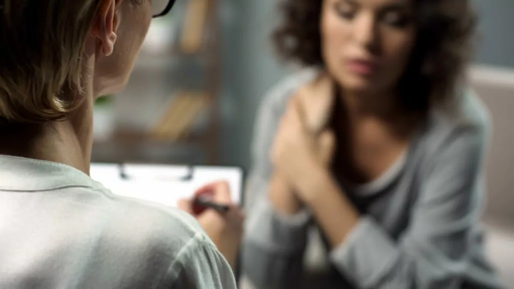 female sitting on a couch with her therapist discussing dual diagnosis treatment