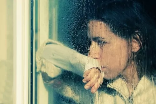 Woman, staring at the window on a rainy day