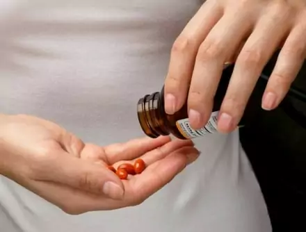 Man pouring pills into his hand, showing signs of painkiller addiction