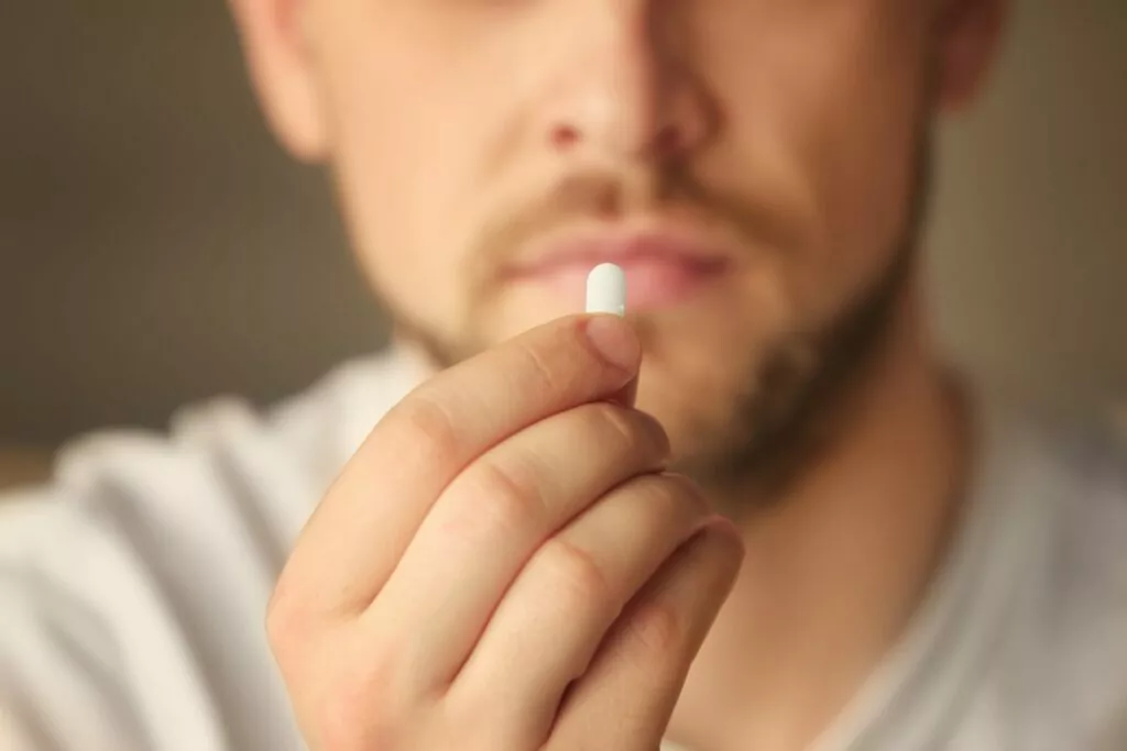 client holding up a pill while at a drug detox center in houston
