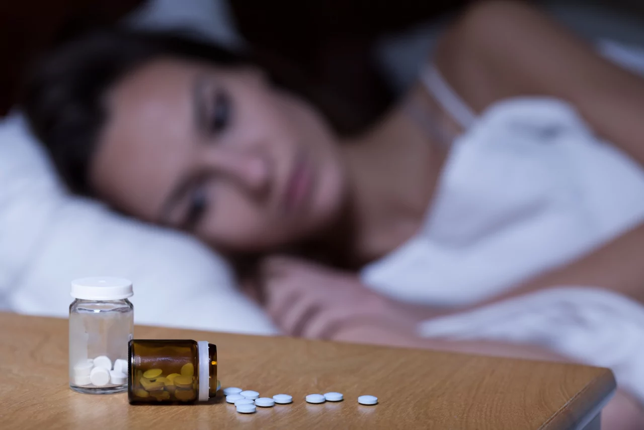 woman laying in bed wondering can you overdose on sleeping pills