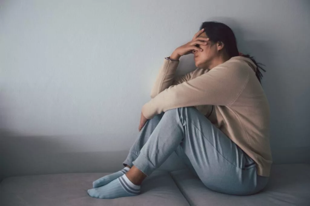 woman with an opioid addiction sits alone