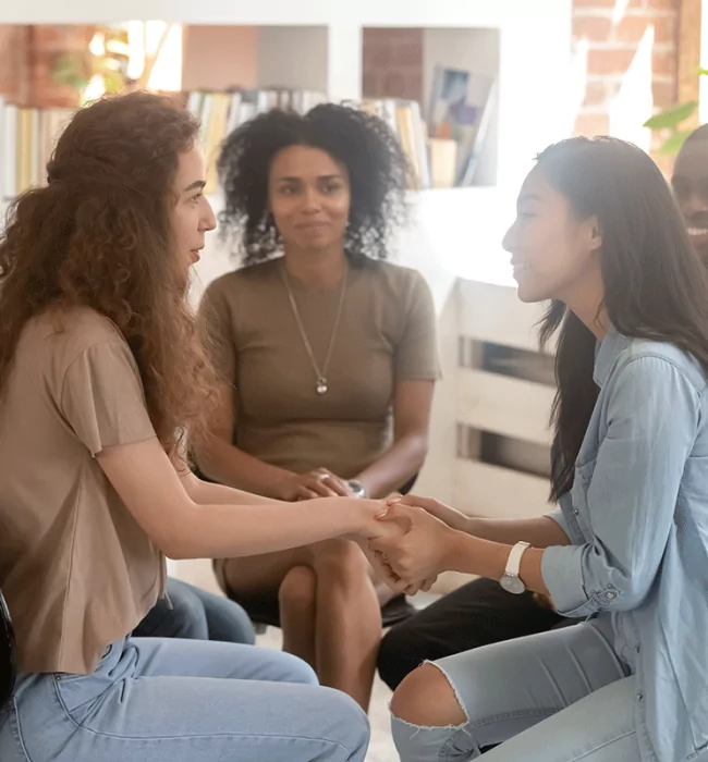 woman sitting in group embracing her therapist