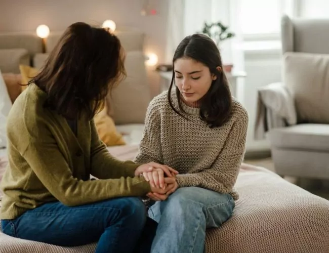 woman sitting with her daughter discussing residential treatment